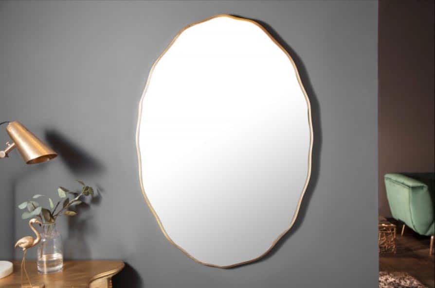 Aj oválne zlaté zrkadlo rozžiari biely interiér. Zdroj: iKuchyne.sk