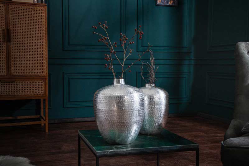 Kovová váza, textilná sedačka a drevené skrinky vytvárajú štýlovú obývačku. Zdroj: iKuchyne.sk